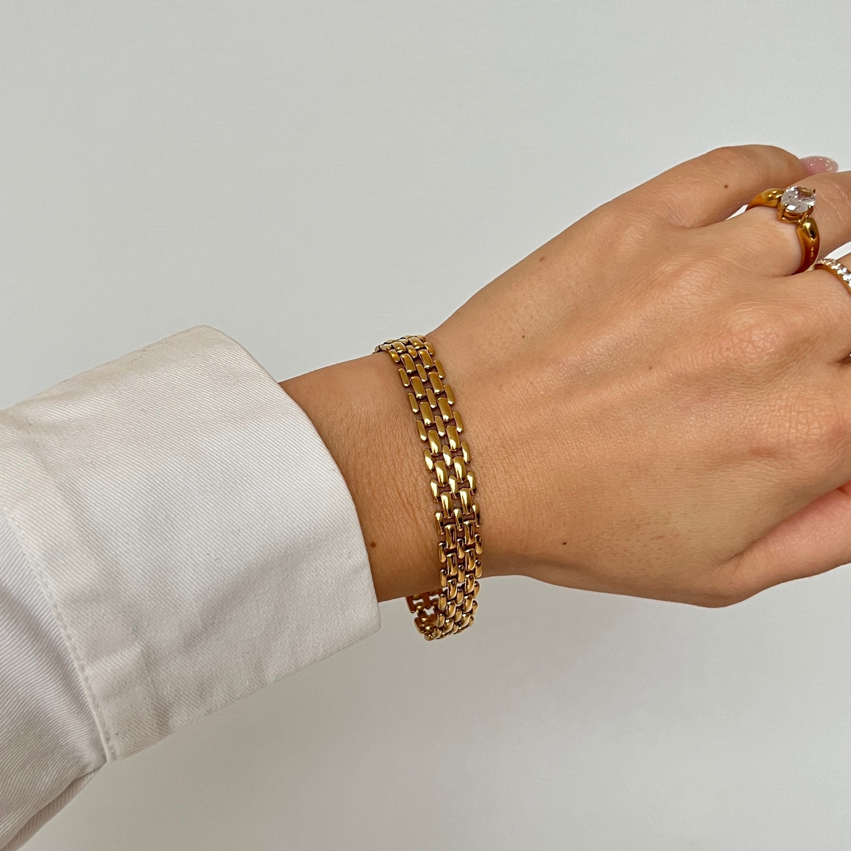 Maya Magnolia Bracelet – guldigt brett armband med eleganta guldlänkar i rostfritt stål och PVD-plätering, vattentåligt och hållbart.