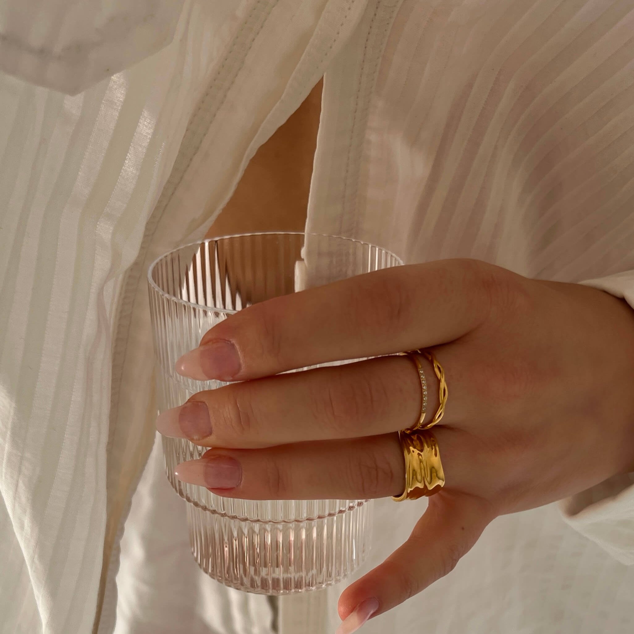 Tunn, flätad guld-ring från Alora Avenue. Serpentine Sea Ring är vattentålig, allergivänlig och designad för att bäras varje dag – oavsett om du doppar händerna i havet eller sippar morgonkaffe i morgonljus. En elegant favorit för dig som vill leva fritt, utan att ta av dina smycken.