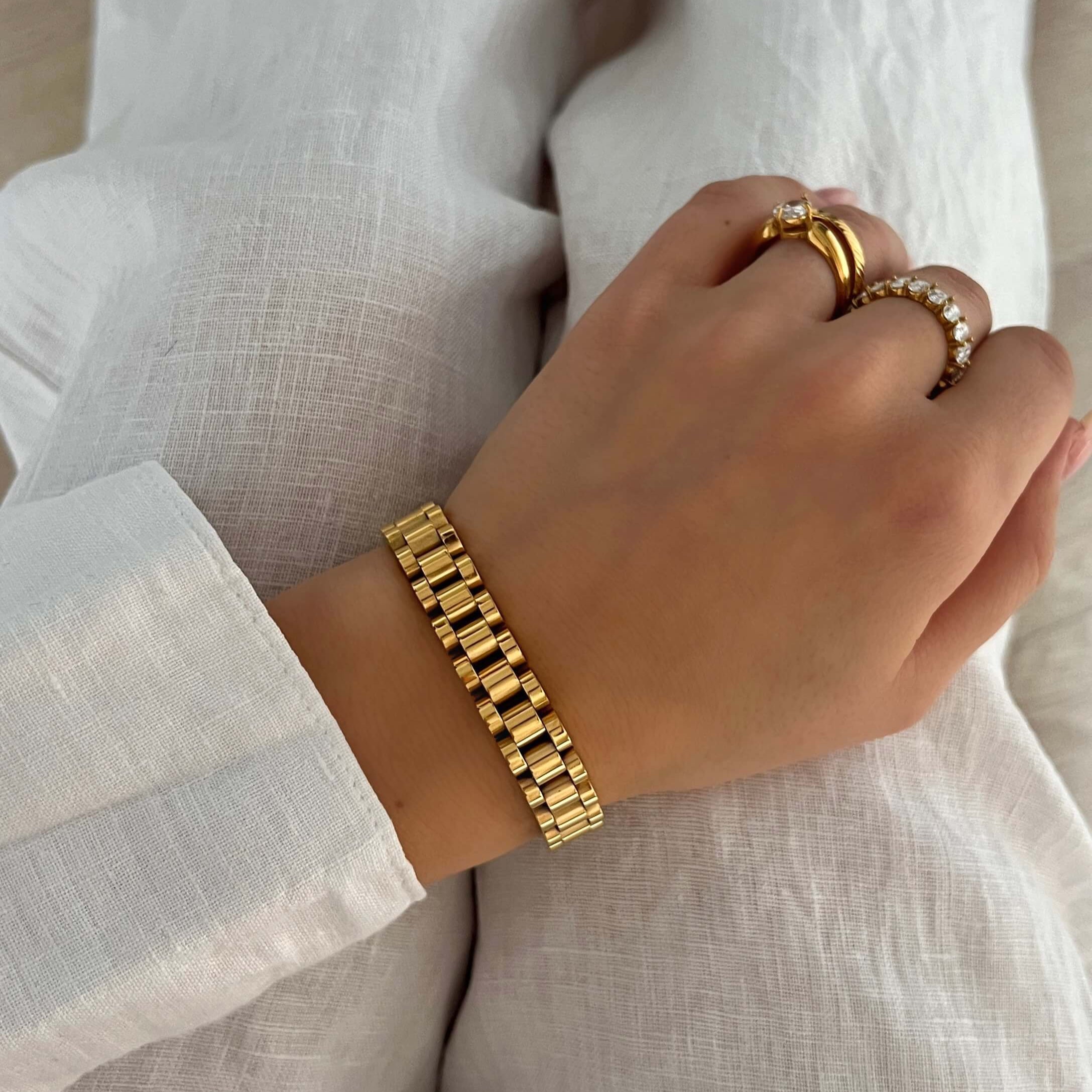 Analog Aria Wristband – stilrent guldfärgat armband i klassisk klockstil med polerad finish. Tillverkat i rostfritt stål med PVD-plätering som är både vattentåligt och allergivänligt. Perfekt accessoar för en tidlös och elegant look.