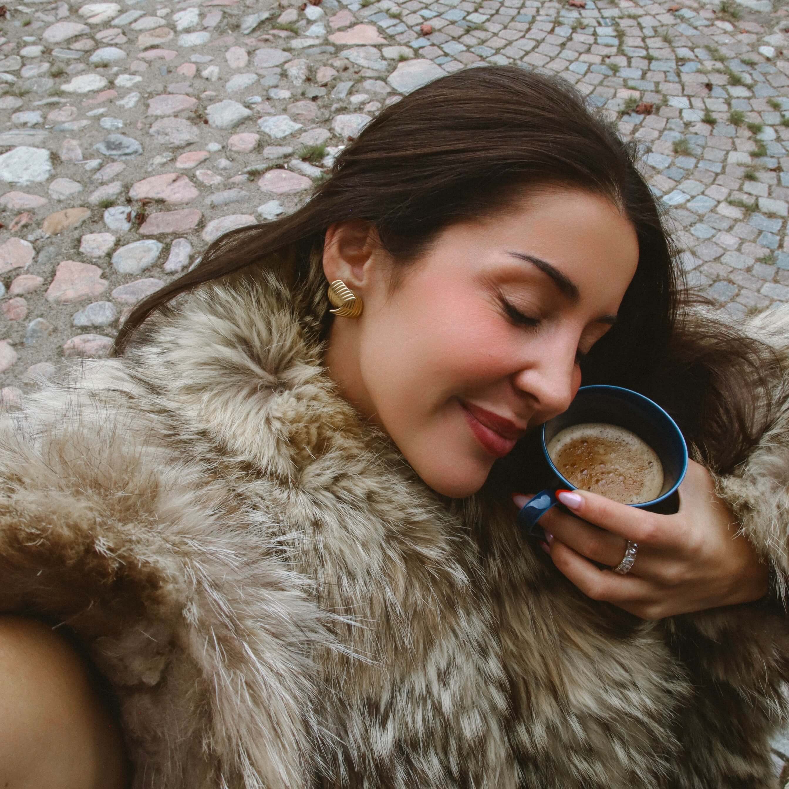 Hanna Huggie Earrings i guld från Alora Avenue – vattentåliga örhängen med elegant böljande form som ger en lyxig, tidlös look.