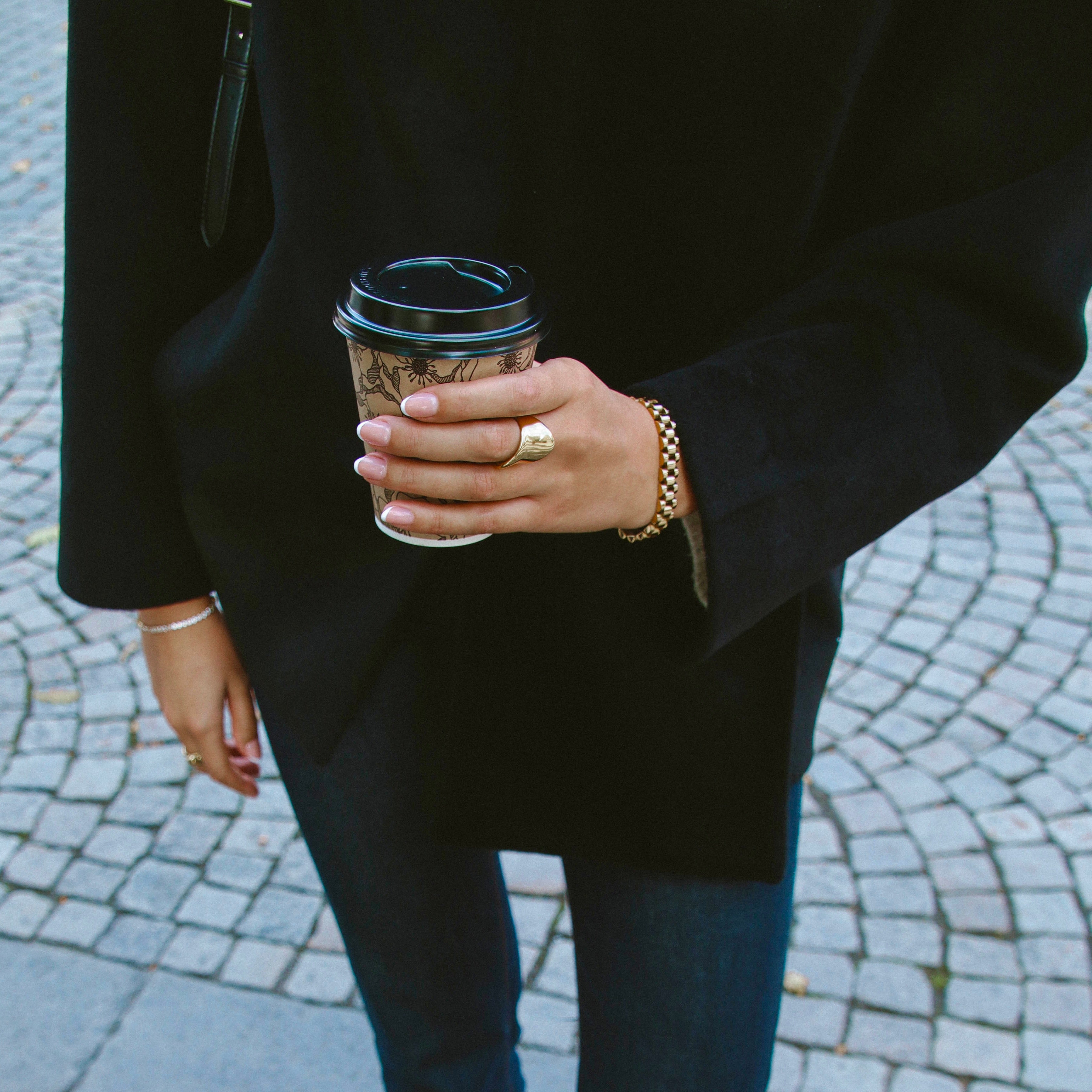 Violet Volume Ring i guld stylad på hand som håller en kaffekopp. Elegant, vattentålig och allergivänlig statementring från Alora Avenue – perfekt för vardag och stil.